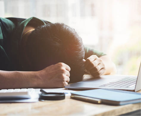 Burnout Syndrome, Man sleeping at his desk working over a laptop,Tried overworked, Freelance man working overload, Young business owner at home office,man feel tried and nap on desk 